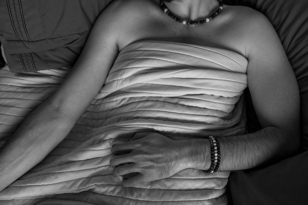 Black and white photo of a mans torso wrapped in a blanket with his arms resting on top. One arm stretches out to the left leaving the hand just out of frame while the other lays on his stomach, palm laying down with fingers slightly curled.

Personal note: What the hell was going through my head when I took this shot...