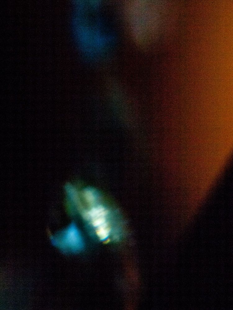 Color photo of a green and blue splotch on a black background with a shade of orange towards the right side. Hints of more colors and light can be seen toward the top of the frame.

Personal note: Next time I try and capture the light shinning through a crystal Im taking it down so I can actually work without constantly fighting gravity.