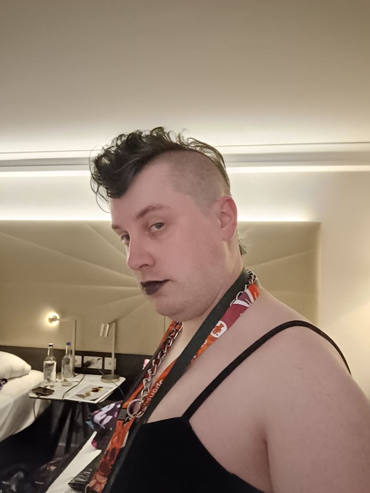 Skirm in a dress, black lipstick, mohawk hair