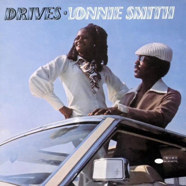 Album cover for Lonnie Smith “Drives.” Lonnie’s looking out of a sunroof with a woman standing next to him.
