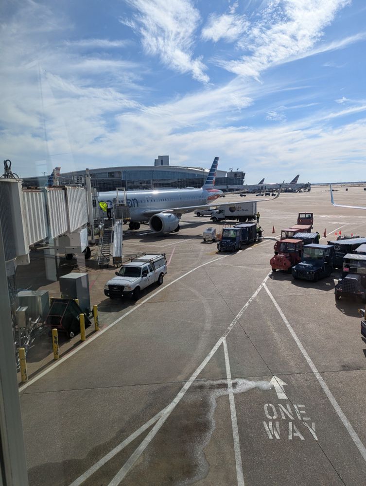 airplane parked at an airport terminal on a clear blue day
