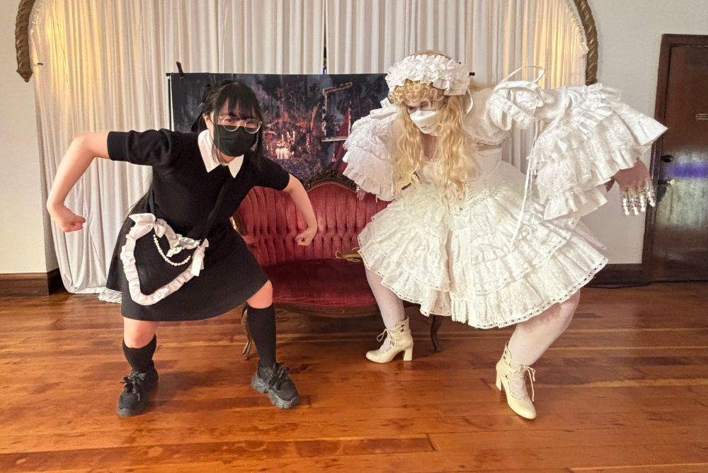 Daisy and Gii pose with their arms in an upside down u shape and squat. Its particularly goofy with Daisy’s princess sleeves