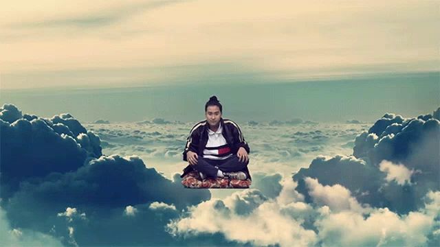 a man in a tommy hilfiger jacket sits on a cloud