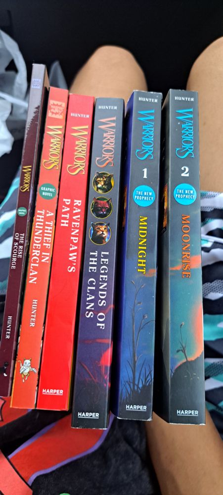 A collection of books being The rise of scourge, A theif in thunderclan, ravenpaws path, Legends of the clans, and Midnight and moonrise from the warrior cats series