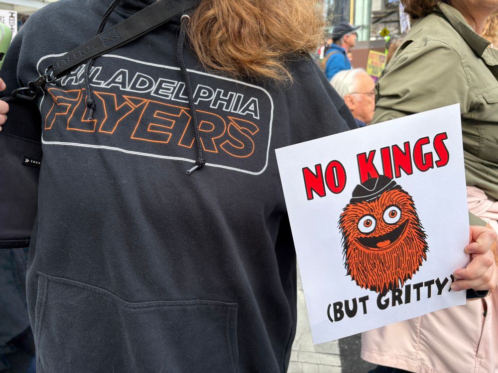 A sign. That says no kings but gritty next to a flyers shirt 