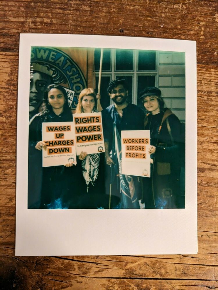 Four individuals holding protest signs advocating for workers' rights and fair wages.
