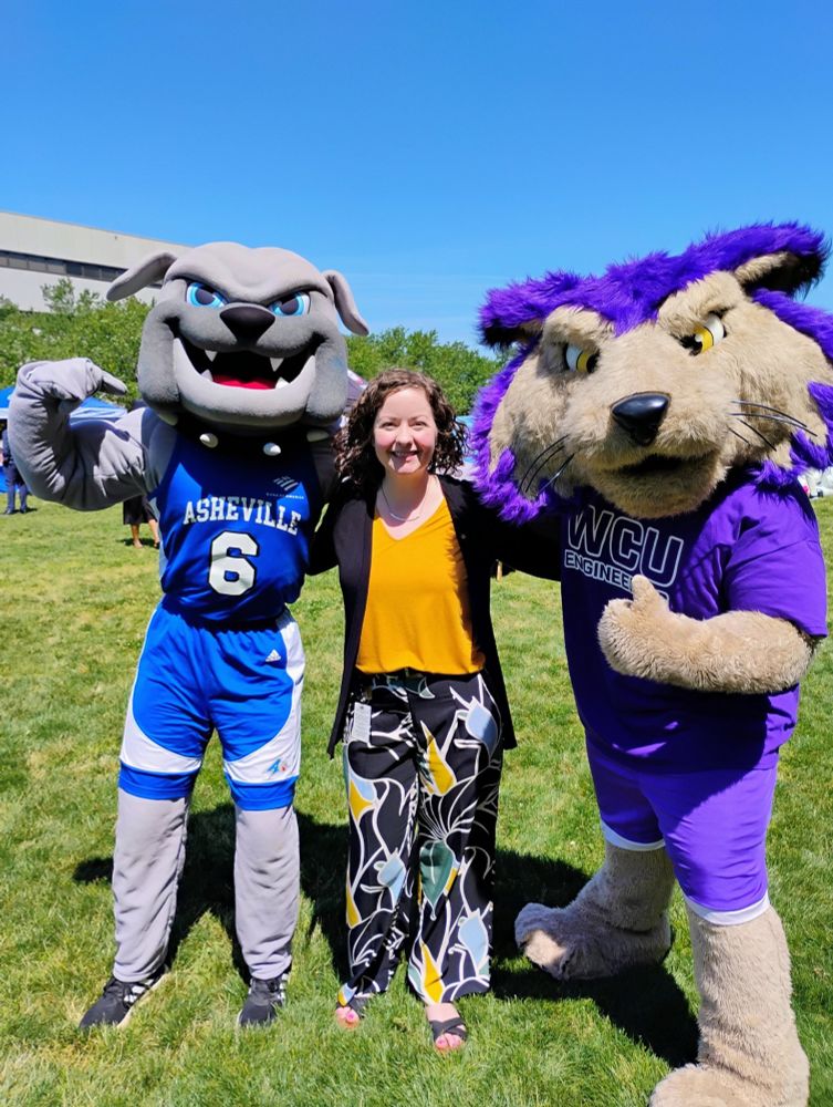 NC House Representative Lindsey Prather (center) stands with the UNC-Asheville mascot on her right and the Western Carolina University mascot on her left.