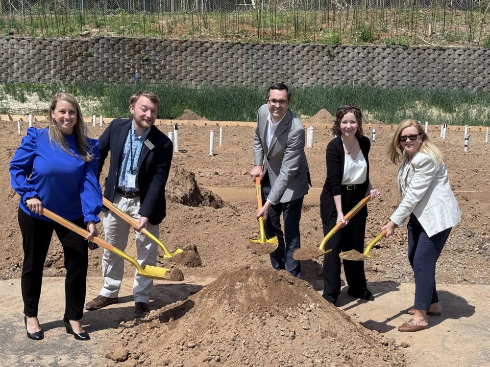 An excited group of project leaders and elected officials pose for a photo with shovels breaking ground on the project.