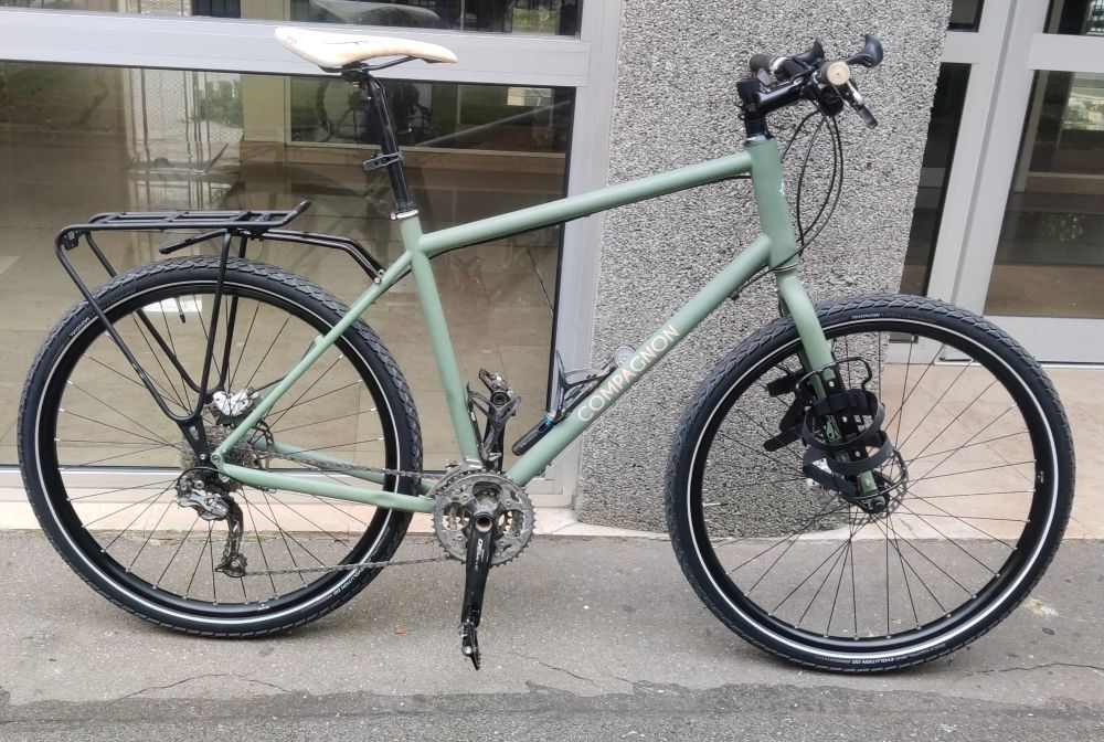 Vélo avec le cadre de la marque compagnon entièrement monté devant un immeuble.