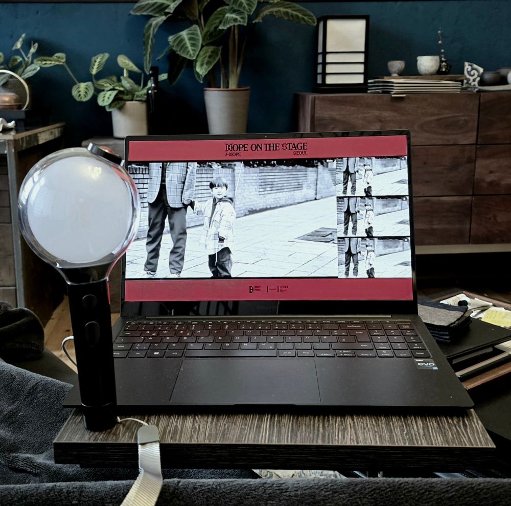 Open laptop with J-Hope on the stage concert and a BTS lightstick at the side