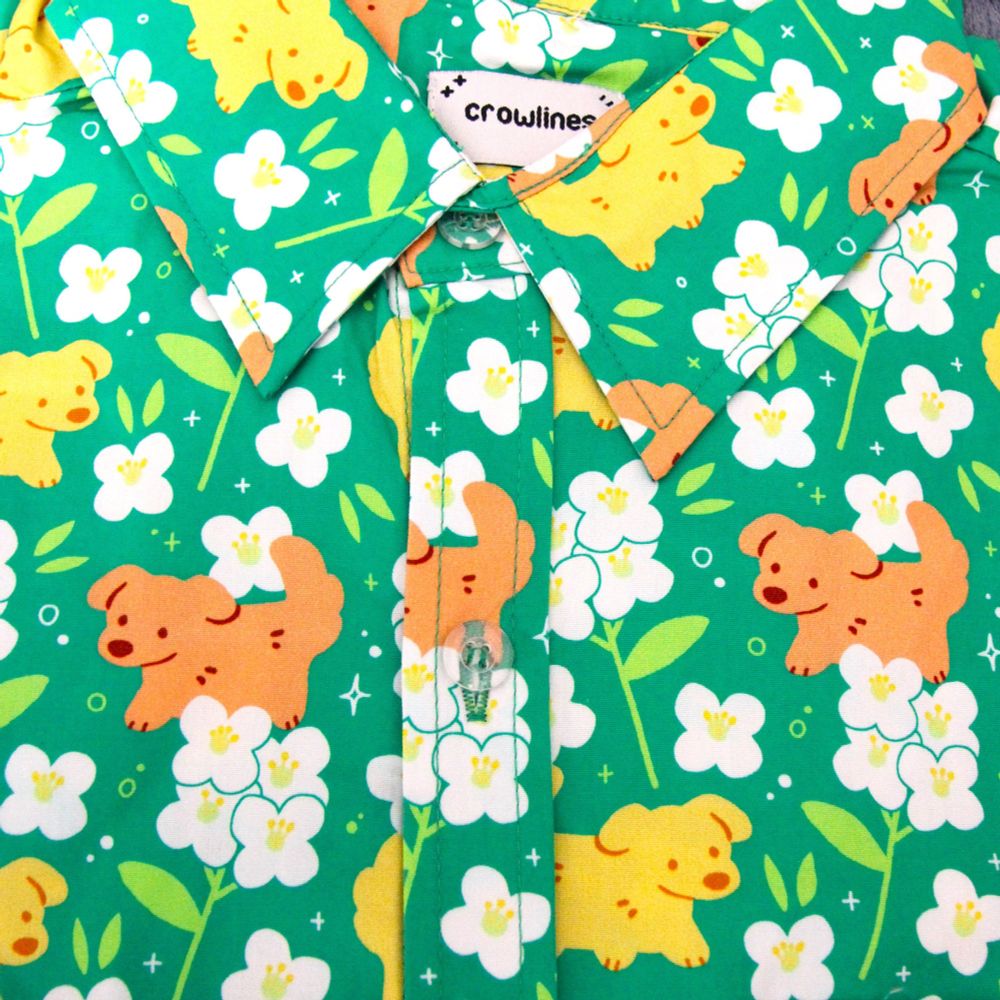 green button up shirt patterned with dogs and white flowers (sweet alyssum)