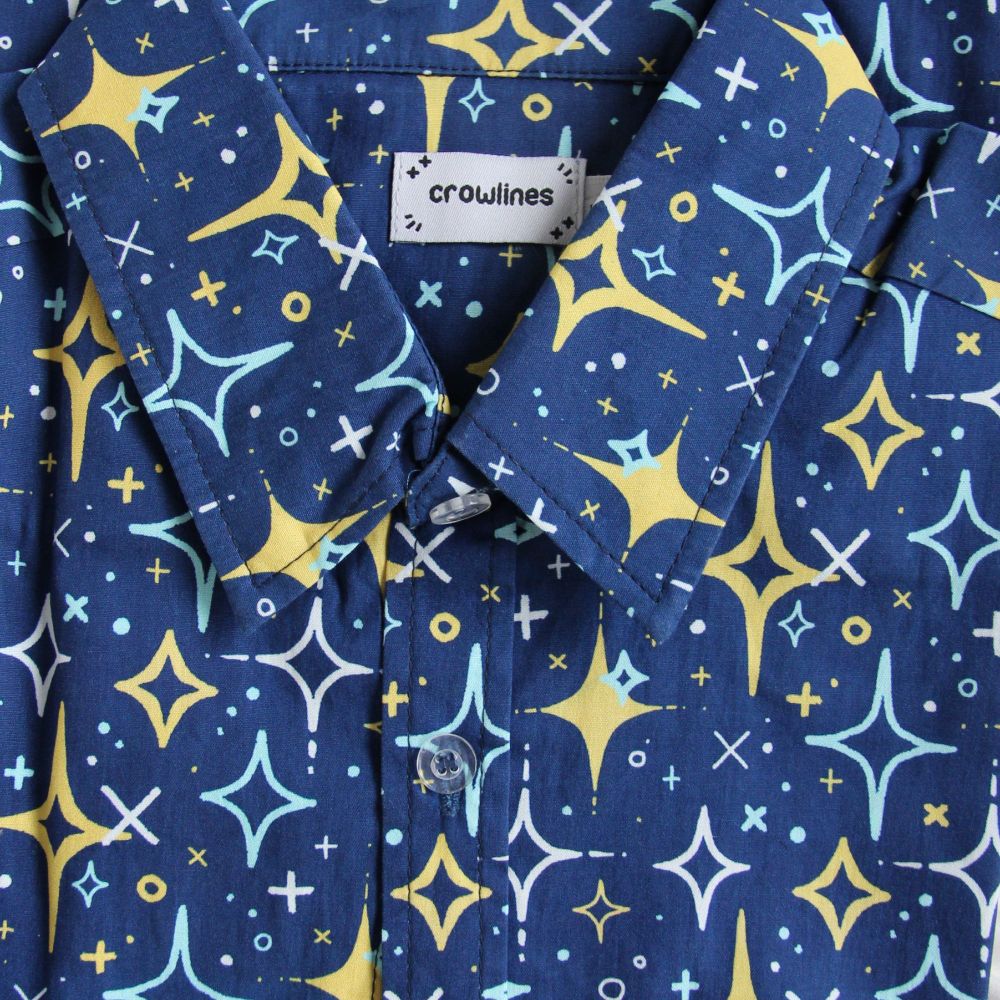 blue button up shirt patterened with yellow, white, and light blue sparkles