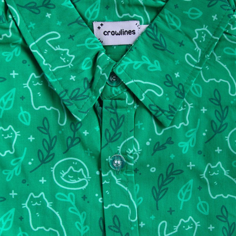 green button up shirt patterned with cats and leaves