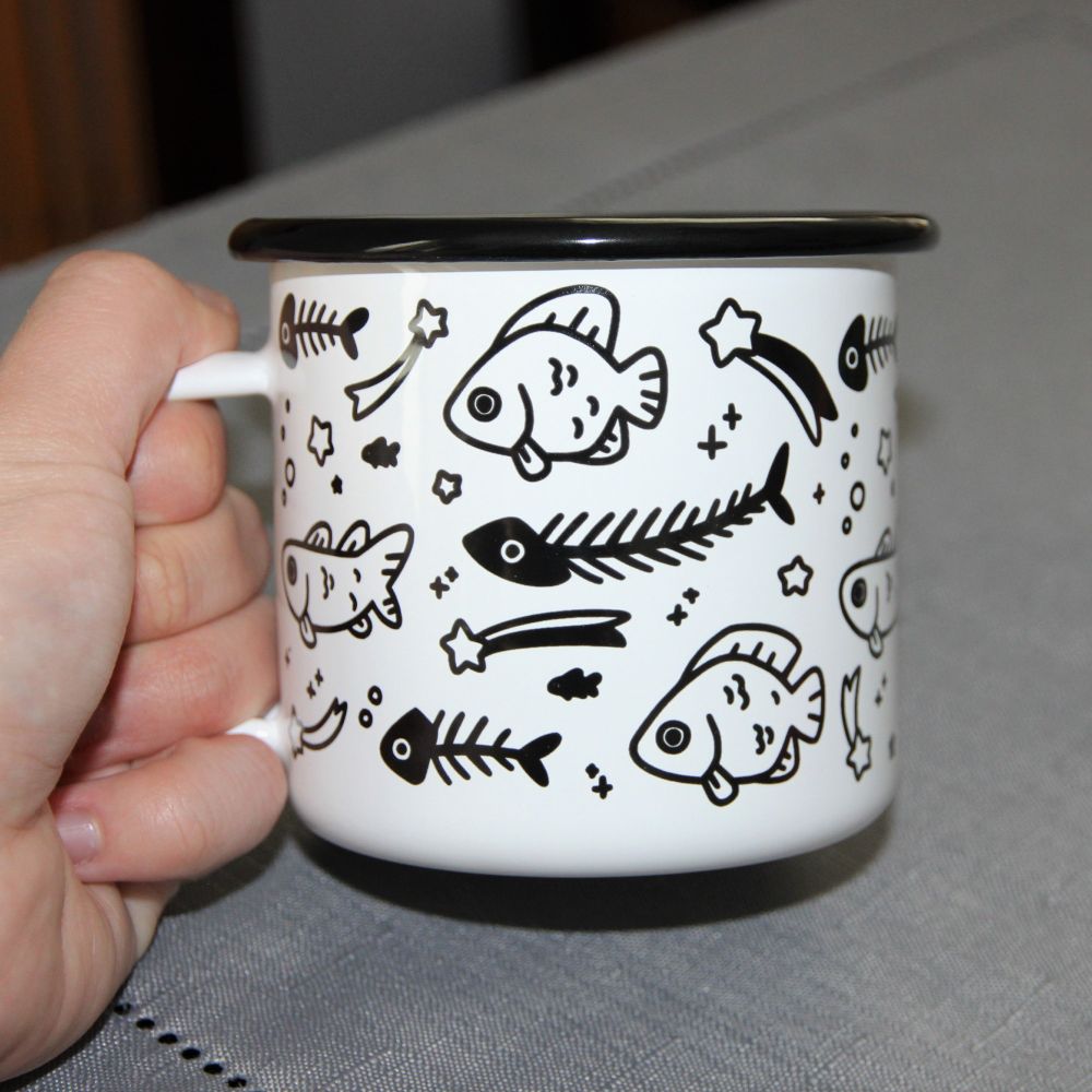 white enamel mug with black print of fish and stars
