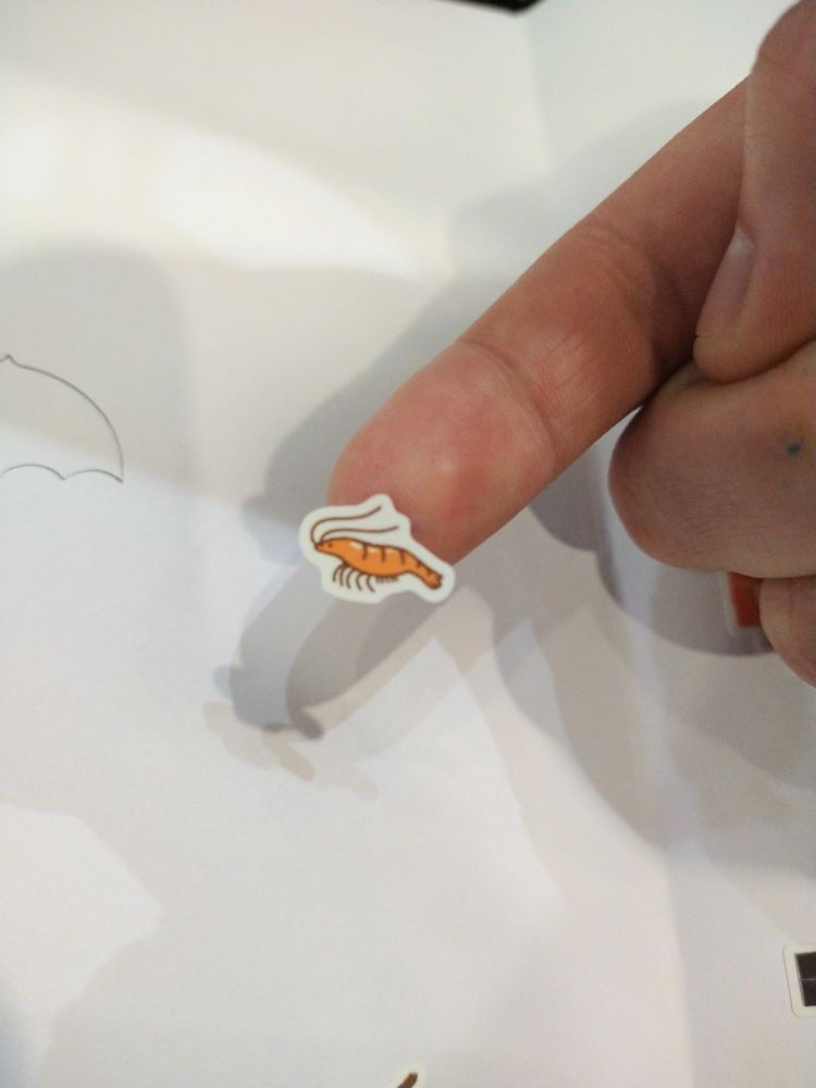Tiny shrimp sticker on a fingertip