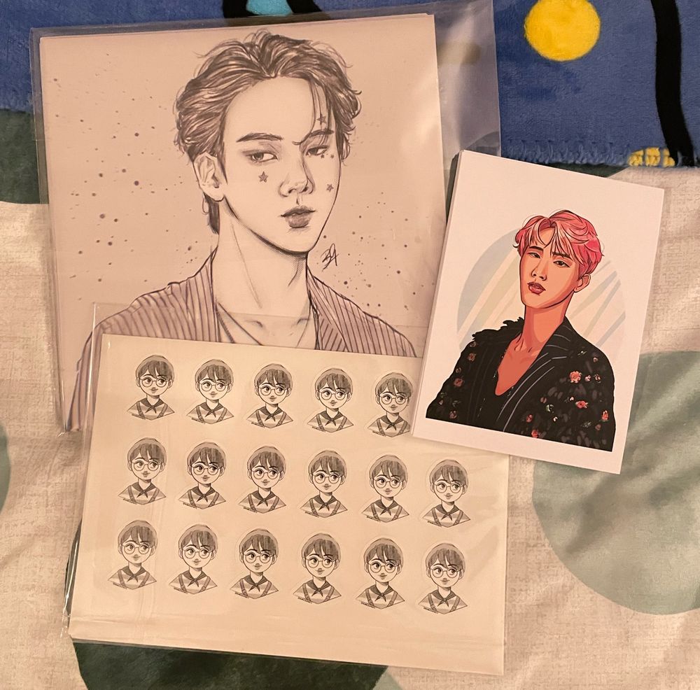 A spread of art prints, stickers and a business card design all made by me. An 8x8 greyscale print of Jin, an A6 print of Jin in colour from the Wings photoshoot, a sticker sheet with mini Jins dressed up for the festa 2016 concert. The Jungkook stickers and business card aren’t in this one.