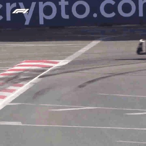 a race car is going around a curve in front of a sign that says crypto.co.