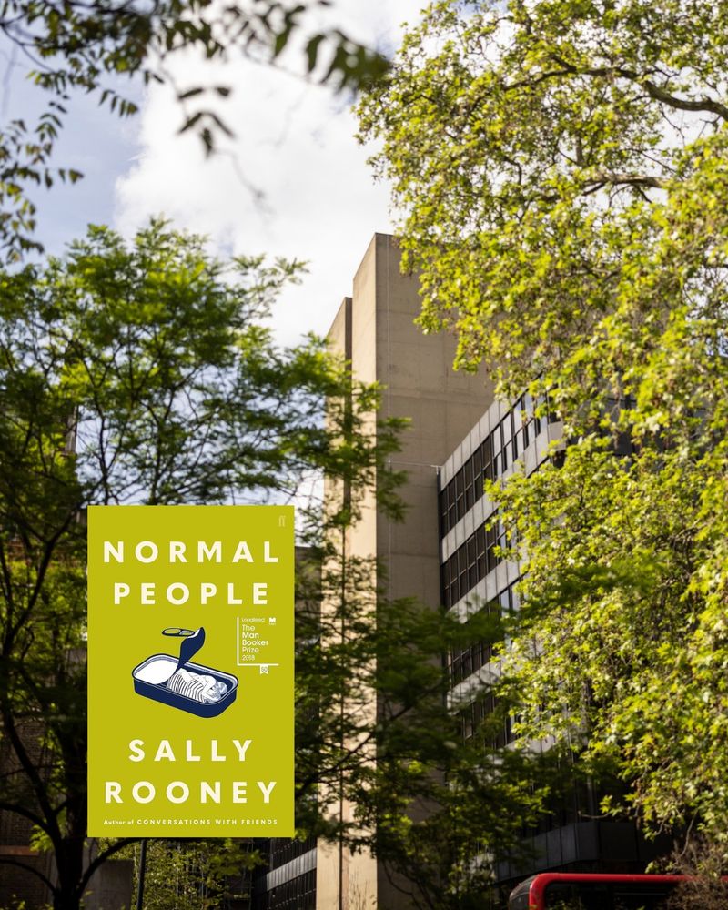 Photo of IOE building covered in foliage and green leaves, in the sun. Accompanying book is Normal People by Sally Rooney, which has a tin of hugging people on a green cover.