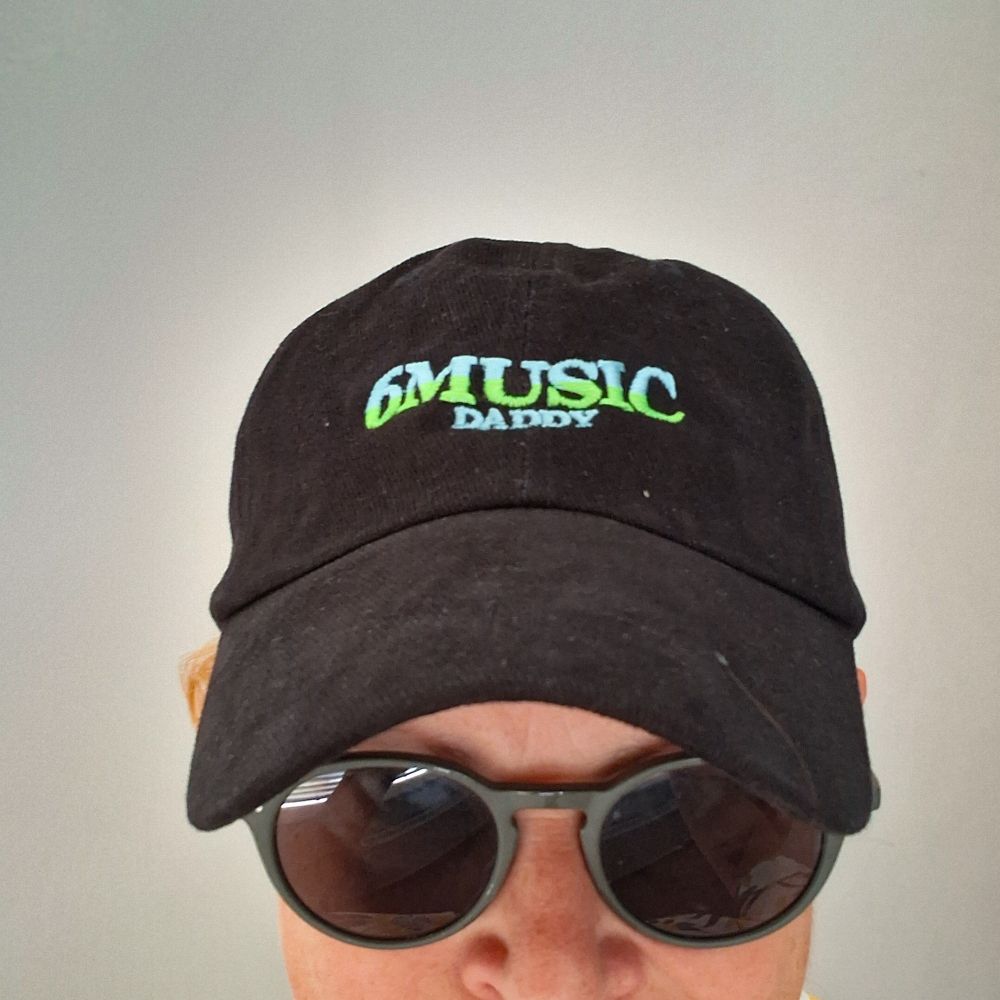 Me wearing a black cap with 6 music daddy on it