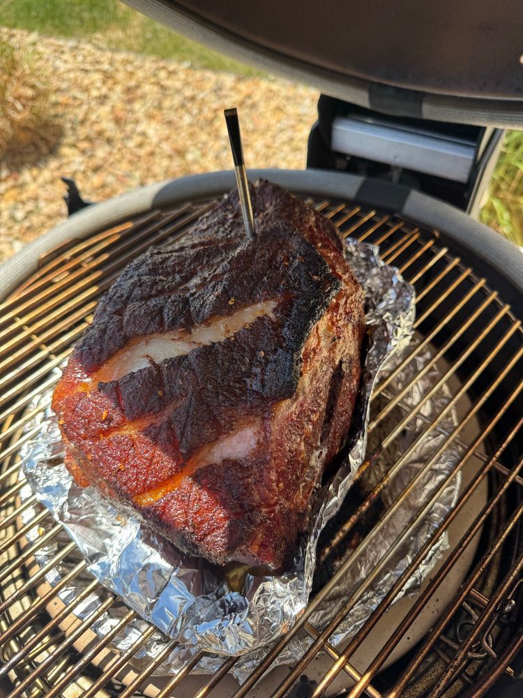 Pork shoulder in an aluminum boat on a grill
