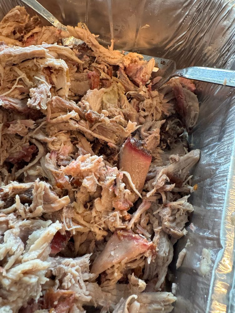 An aluminum tray full of pulled pork.
