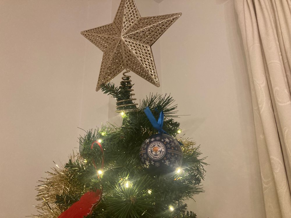 The top of a Christmas tree with a big gold sparkly star on top … and a blue Leicester City baubel