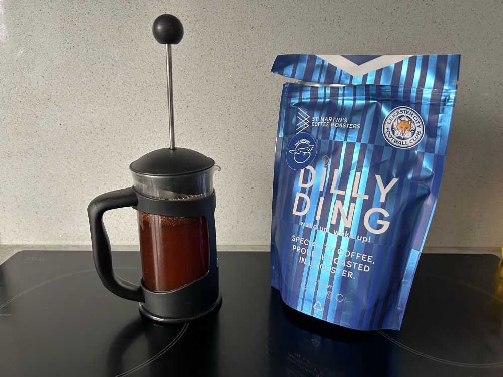 A small cafetierre full of coffee next to a pack of dilly ding coffee with the Leicester city logo on it, from St Martin’s coffee roasters in Leicester