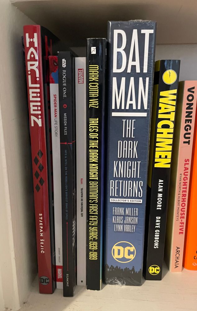 A selection of graphic novels, including the Dark Knight trilogy, Watchmen, Harleen, and Spider-Man Life Story.