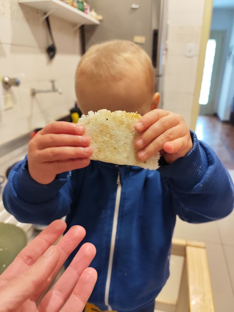 Bebê grande segurando uma mini tapioca com recheio de banana