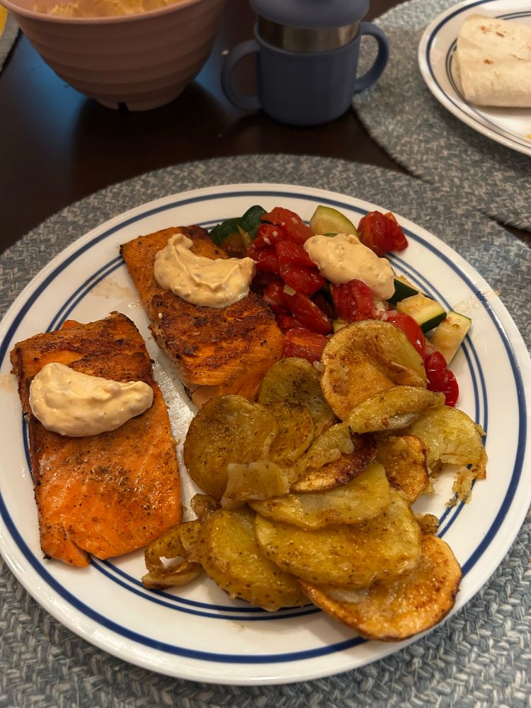 Grilled salmon with potatoes and zucchini and tomatoes with a spicy aioli sauce.