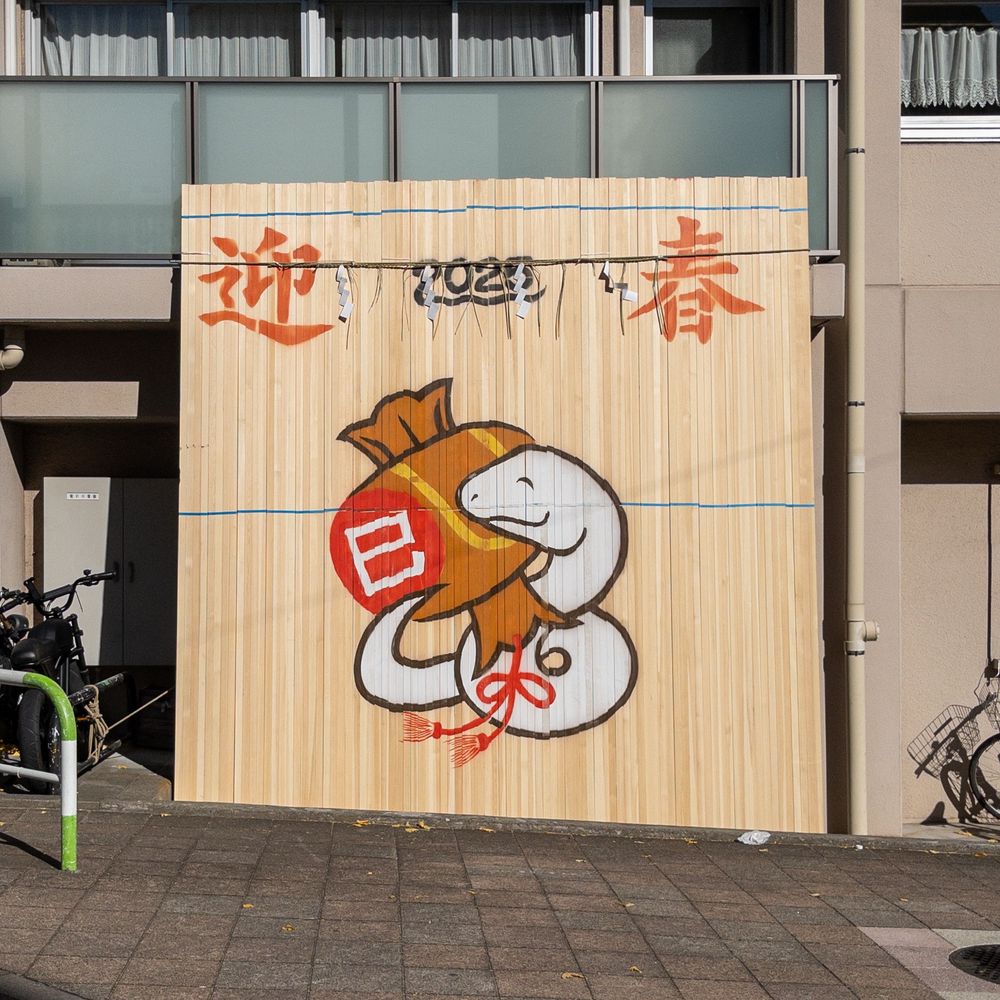 Tall wooden slats with painting of white snake welcoming the new year