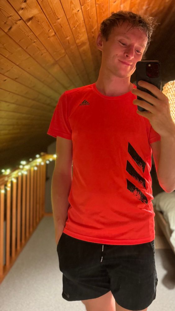 Post run selfie wearing neon orange Adidas running shirt and black Nike running shorts