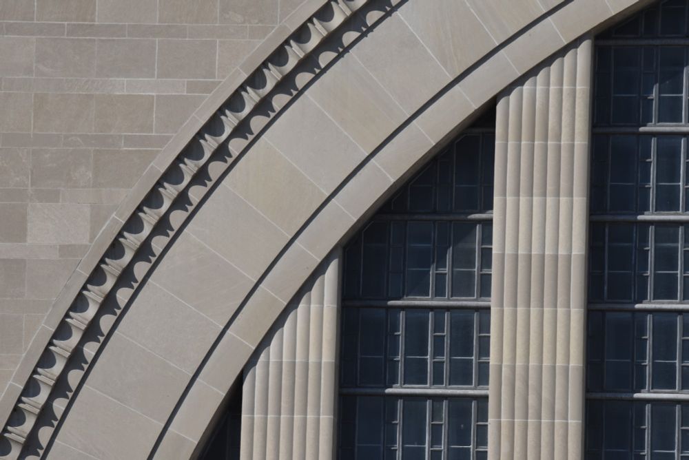 A close-up image of Cincinnati's Union Terminal showing the details within the curve of the half-circle facade framing the building's front windows.