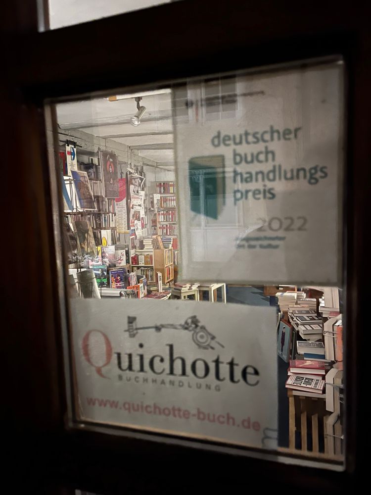 Nahaufnahme der Tür des Quichotte mit Namensschild und einem Schild „Buchhandlungspreis 2022“