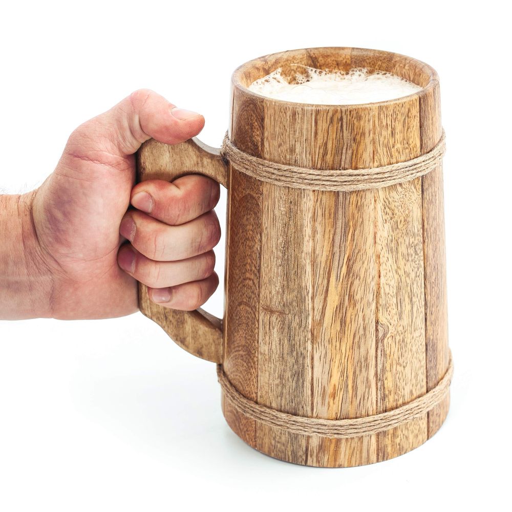Wooden tankard with rope binding, full of a frothy drink. 