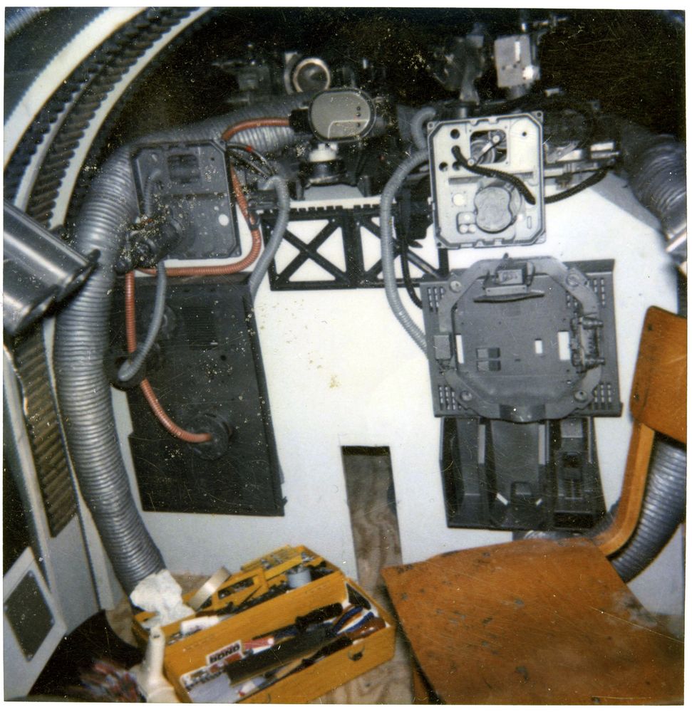 Behind the scenes RotJ photo of the rear of a B-wing cockpit interior set, with a toolbox and a wooden chair in it.