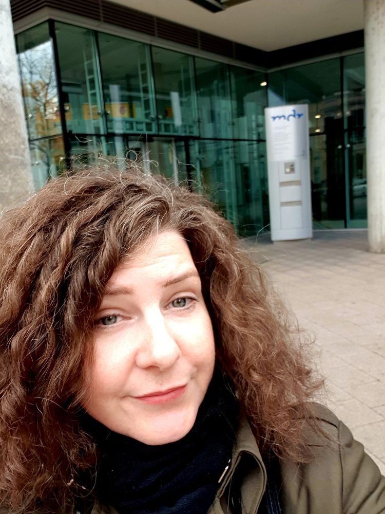 Das Bild zeigt die Verfasserin des Posts vor der Tür des MDR in Halle/Saale.