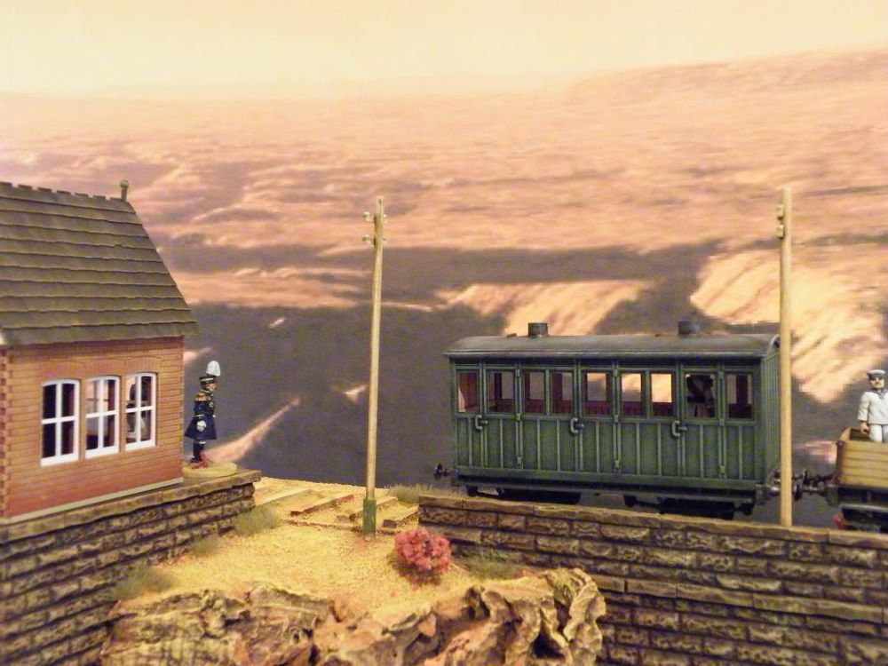 A Japanese officer on the left watches a train depart to the right from the station. 