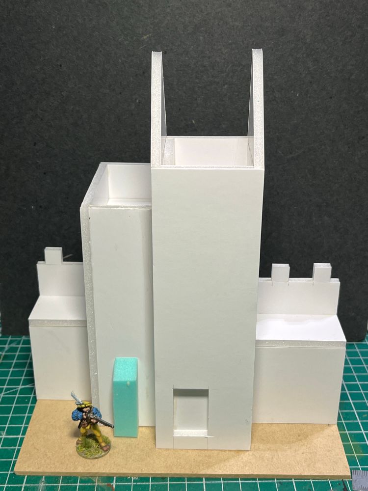 A rear view of the town wall section. There is a smaller, but taller tower on the back of the main tower and it will have a tiled roof. The handgunner has come down from the tower as he’s thirsty and wants an ale. 