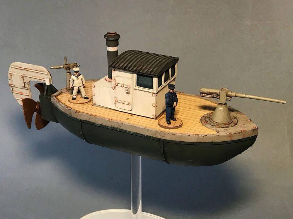 One of our aeroneff scout ships (facing to the right). It’s armed with a deck gun and two crew are on the deck (quite possibly posing for the camera). Lower hull is dark grey, wheel house is white and the deck is veneer (supplied with the kit). 