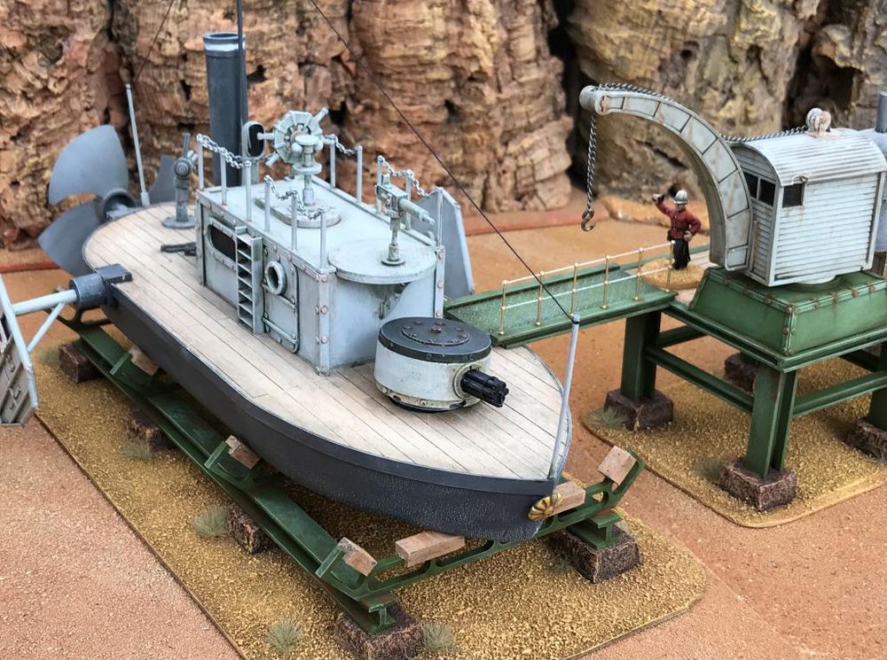A ‘neff’ is docked on a ground based dry dock with a crane on the right ready to load up on more ammunition. 