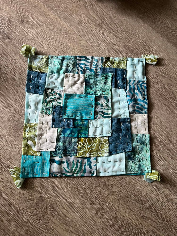 A patchwork quilt of blue and green batique fabric