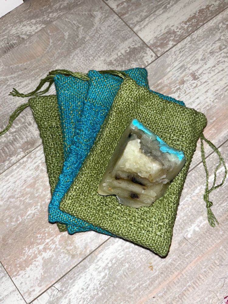 4 blue and green bags with drawstrings and a lump of soap