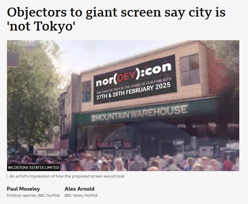 An altered image of a BBC Article regarding a new billboard in Norwich City Centre. The headline "Objectors to giant screen say city is 'not Tokyo'. The mockup image of the billboard has been updated to contain an advert for the Norfolk Developers Conference instead of the generic advert previously used.