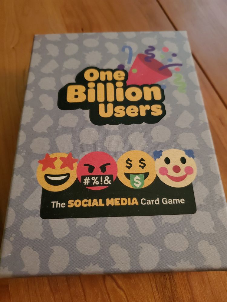 The box for the card game "One Billion Users: The Social Media Card Game". It is decorated with emojis.