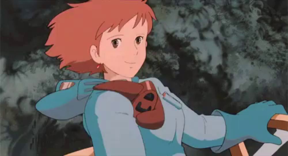 a girl with red hair is wearing a blue jacket and blue gloves .