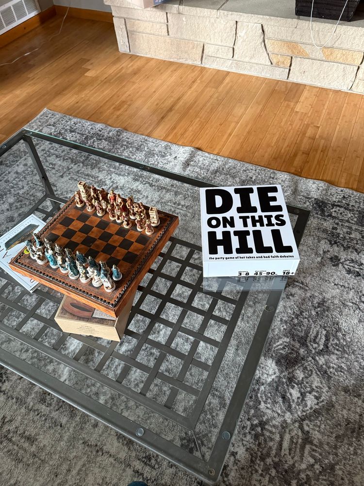 off center picture of the die on this hill game box on a glass coffee table with a chess set to the left to make it look classy