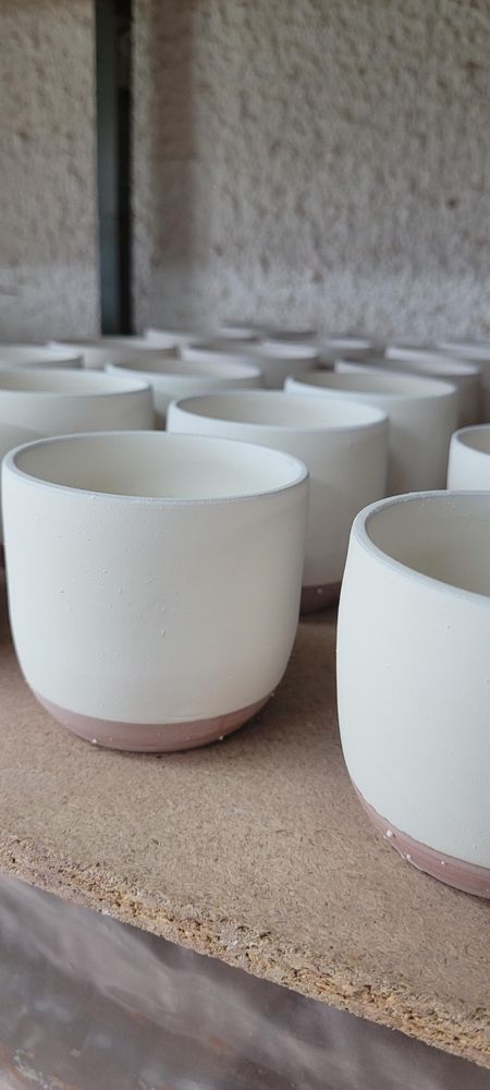 Tasses à café émaillées en attente de cuisson. 