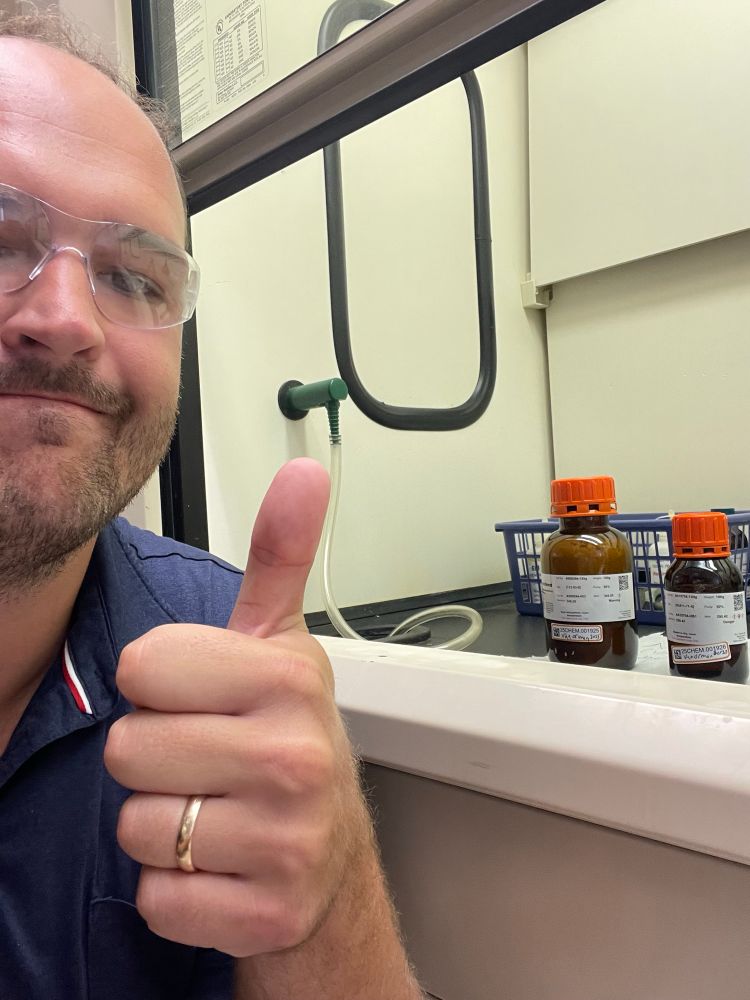 Me giving a thumbs up in front of two chemical bottles. 