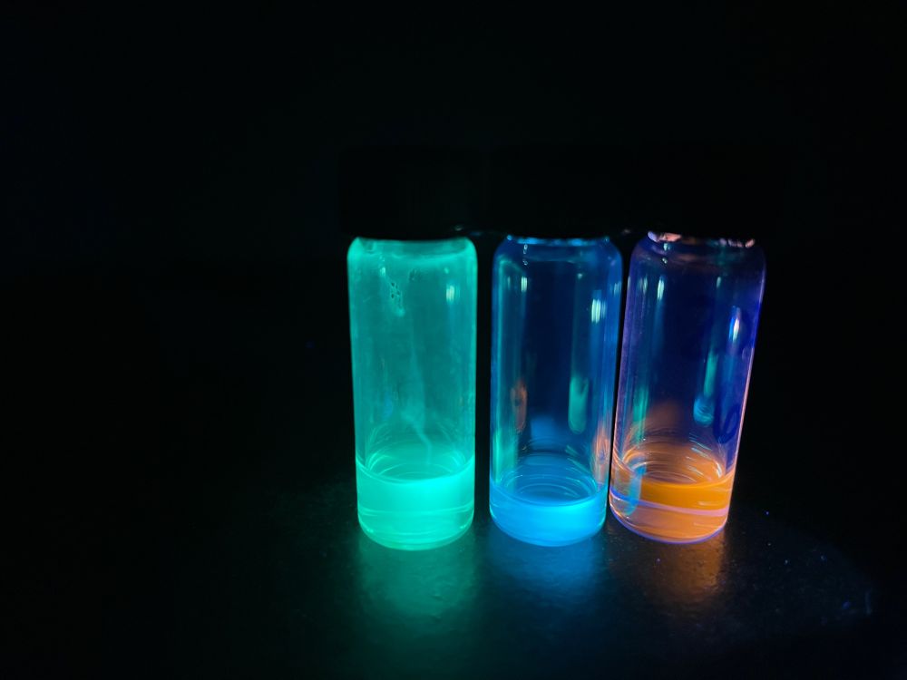 3 vials containing quantum dots with green, blue, and orange emission, respectively.